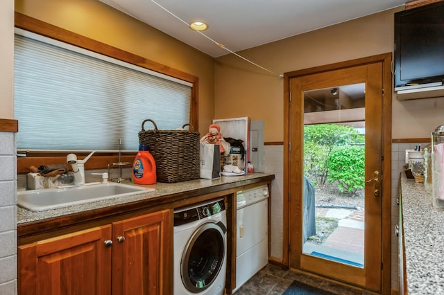 laundry area featuring sink, independent washer and dryer, a healthy amount of sunlight, and dark tile flooring