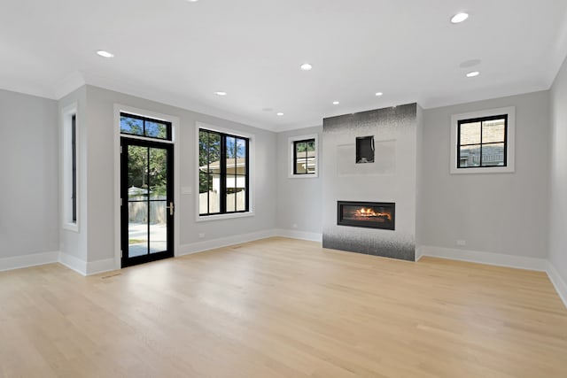 unfurnished living room with crown molding and light wood-type flooring