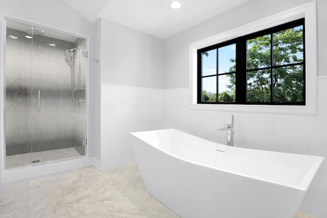 bathroom featuring tile walls and shower with separate bathtub