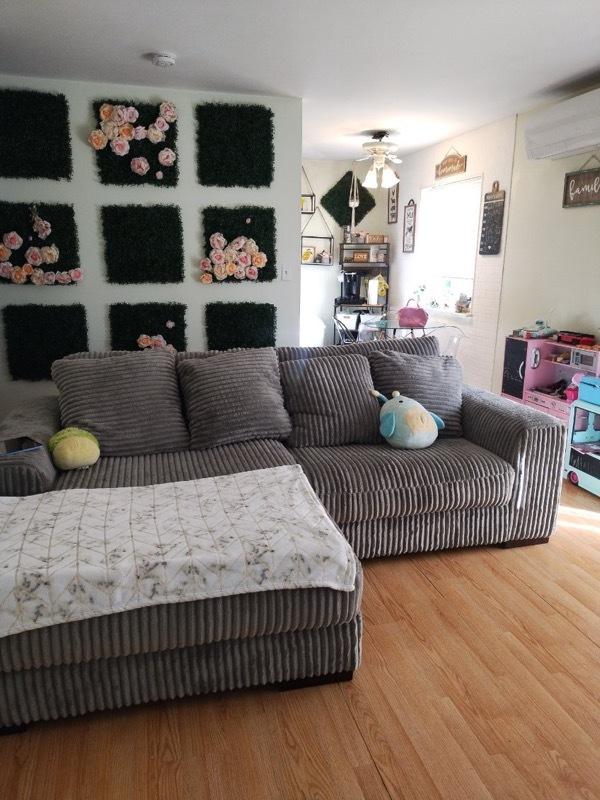 living room featuring a wall mounted AC, hardwood / wood-style flooring, and ceiling fan