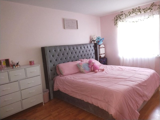 bedroom with dark hardwood / wood-style flooring