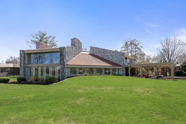 rear view of property with a playground and a lawn