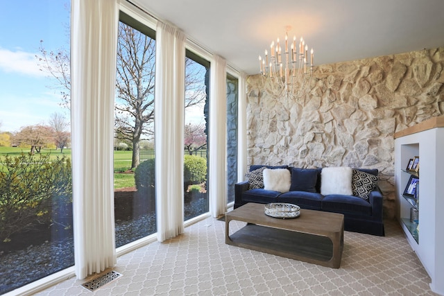 sunroom / solarium featuring a chandelier