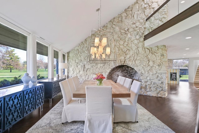 dining space with high vaulted ceiling, an inviting chandelier, and dark hardwood / wood-style floors