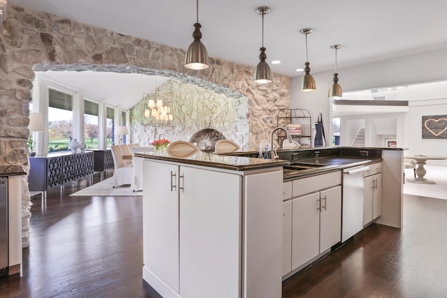 kitchen with hanging light fixtures, sink, white cabinetry, and dark wood-type flooring