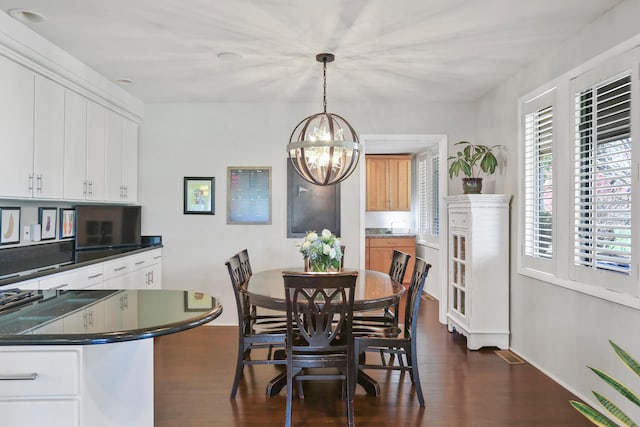 dining space featuring dark wood-type flooring and a chandelier