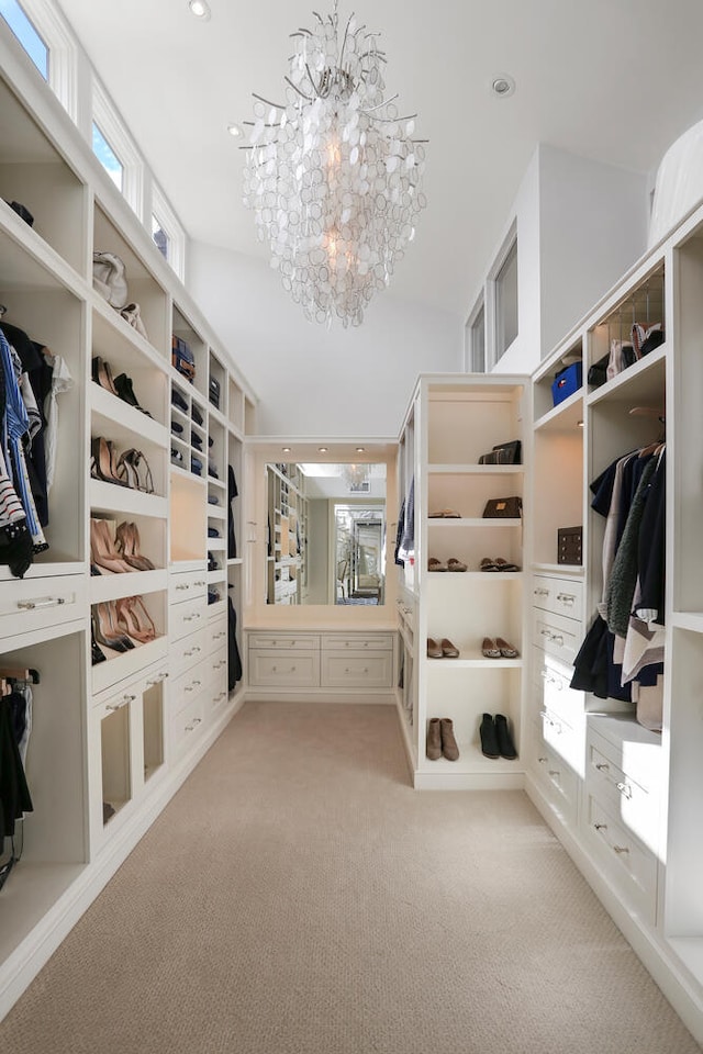 spacious closet with a notable chandelier and carpet