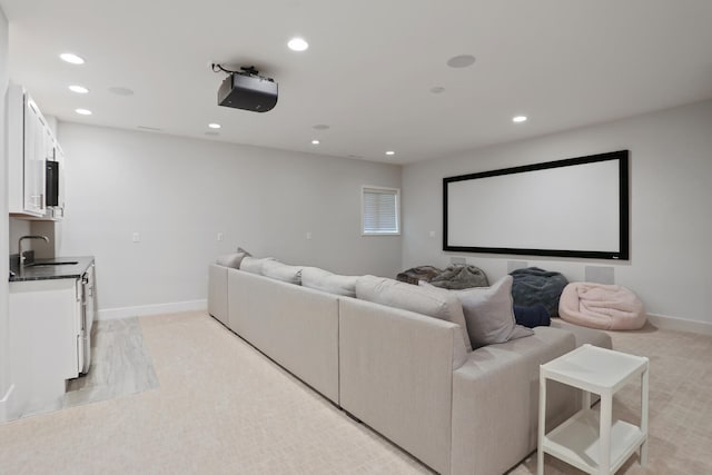 home theater with sink and light colored carpet