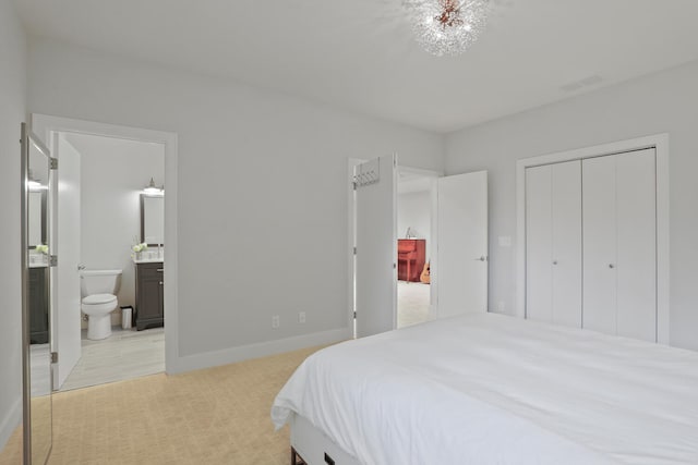 bedroom featuring ensuite bathroom, a closet, and light colored carpet