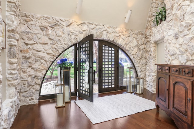 entryway with dark hardwood / wood-style flooring and vaulted ceiling