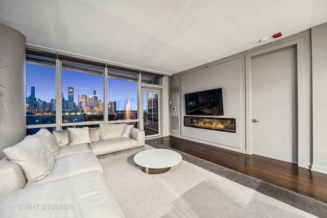 living room with dark hardwood / wood-style floors and a wall of windows