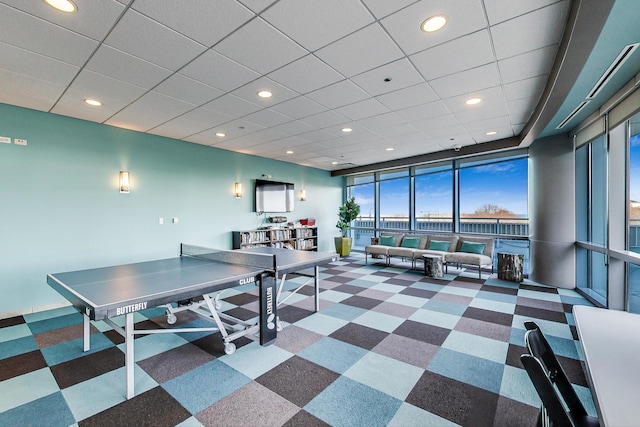 interior space with a paneled ceiling and floor to ceiling windows