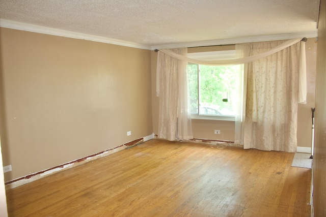 empty room with light hardwood / wood-style flooring, a textured ceiling, and crown molding