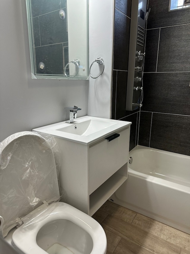 full bathroom with tiled shower / bath combo, oversized vanity, and toilet