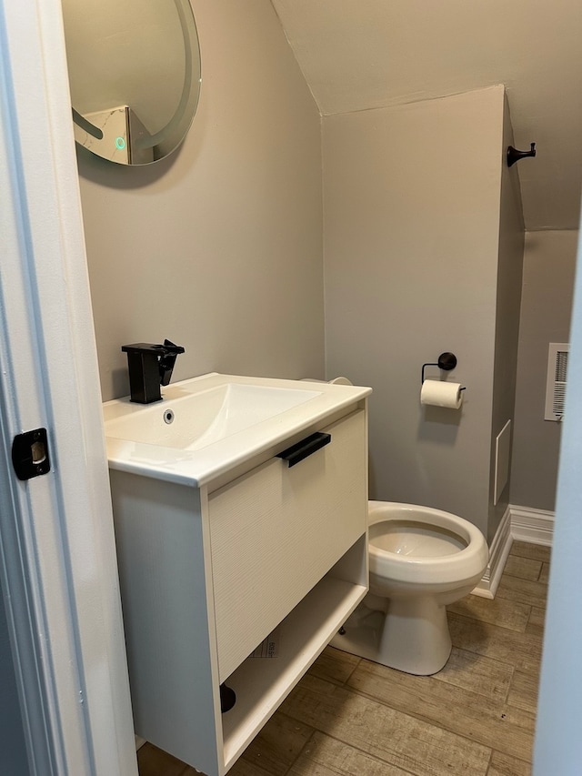 bathroom with vanity, hardwood / wood-style flooring, and toilet