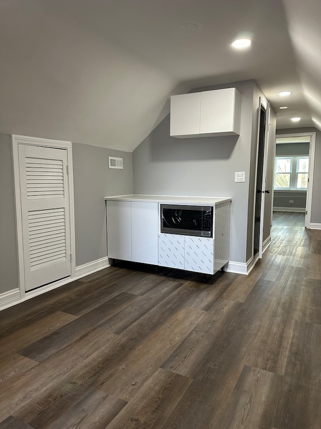 interior space with dark wood-type flooring and lofted ceiling