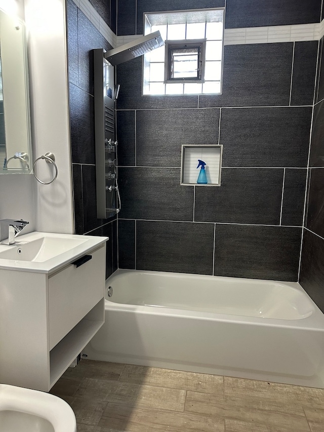 bathroom featuring vanity and tiled shower / bath