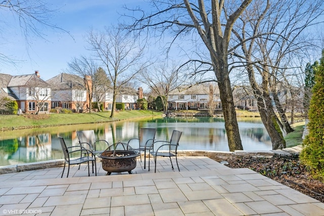 view of patio / terrace with a fire pit and a water view