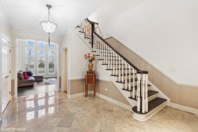 stairway featuring crown molding and a notable chandelier