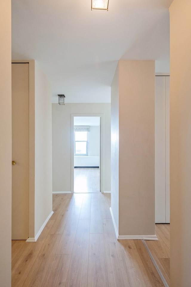 corridor with light hardwood / wood-style flooring