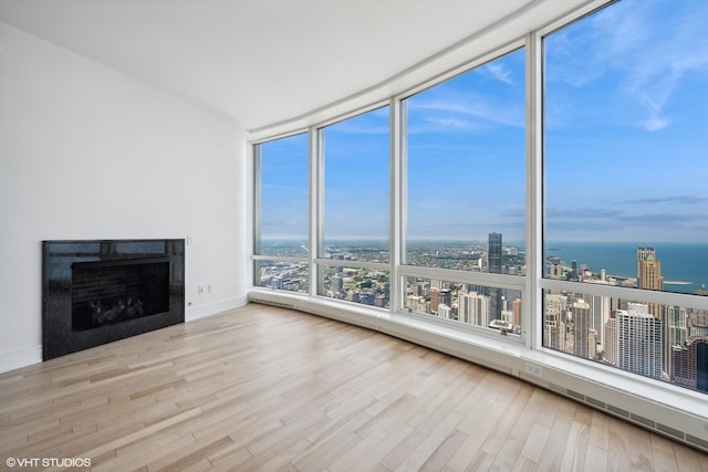 401 N Wabash Ave Unit 75A, Chicago, IL 60611 - unfurnished living room featuring a view of city, wood finished floors, a fireplace, floor to ceiling windows, and a water view