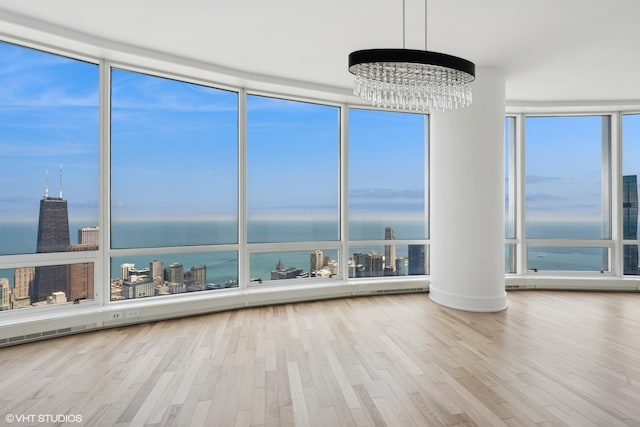 interior space with hardwood / wood-style floors, a notable chandelier, and a water view