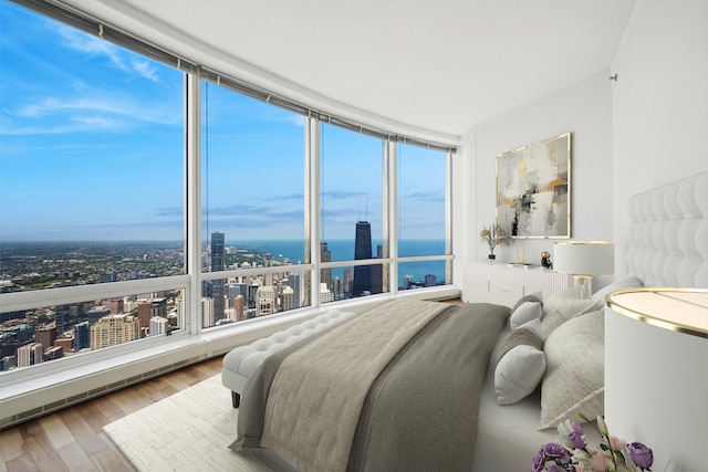 bedroom with hardwood / wood-style flooring, a water view, a wall of windows, and multiple windows