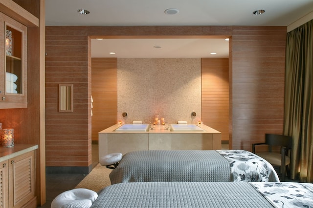 bathroom with a bath and wood walls