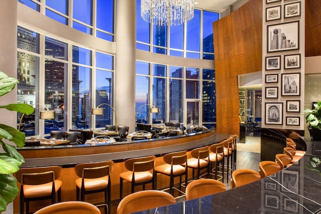 bar featuring a towering ceiling and a chandelier