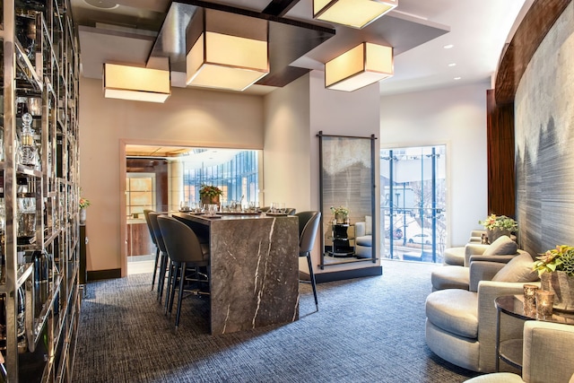 carpeted dining space featuring a high ceiling and a healthy amount of sunlight