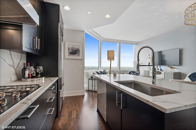 kitchen with custom range hood, a kitchen island with sink, floor to ceiling windows, dark wood-type flooring, and sink