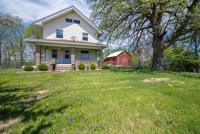 back of house featuring a lawn and covered porch