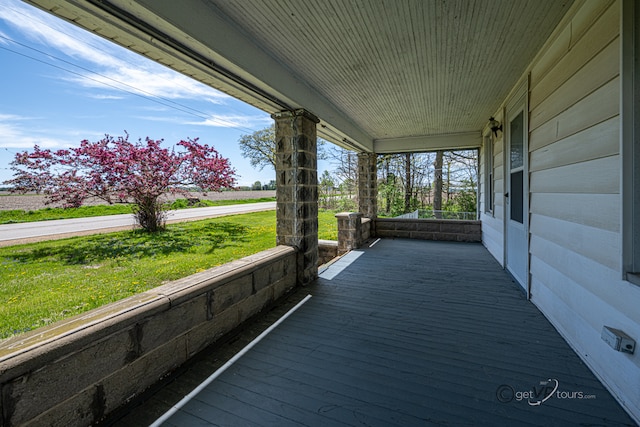 wooden terrace featuring a lawn