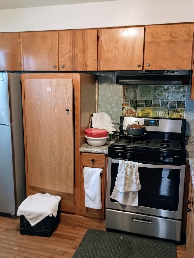 kitchen with light hardwood / wood-style floors and appliances with stainless steel finishes