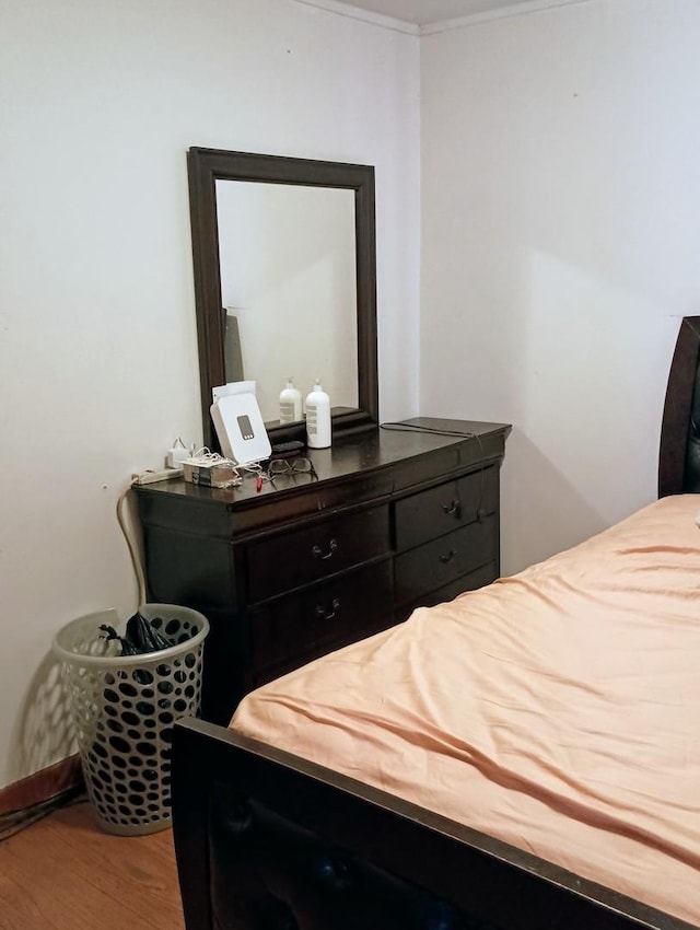 bedroom featuring wood-type flooring and ornamental molding