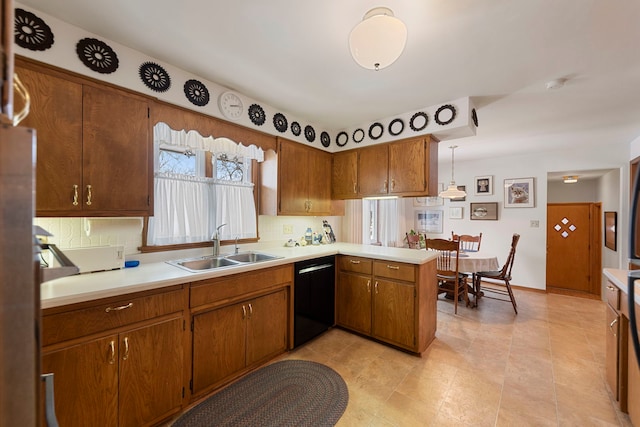 kitchen featuring sink, dishwasher, tasteful backsplash, decorative light fixtures, and kitchen peninsula