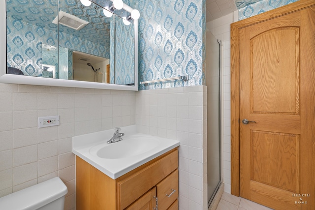 bathroom featuring oversized vanity, tile walls, an enclosed shower, and toilet