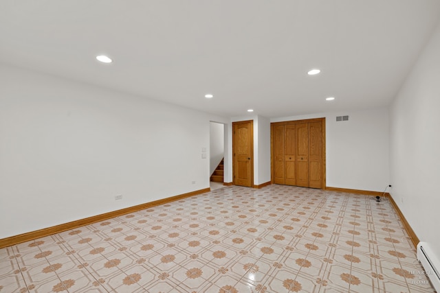 unfurnished bedroom featuring a closet, light tile flooring, and baseboard heating