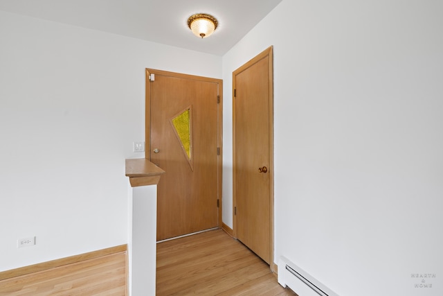 foyer with baseboard heating and light hardwood / wood-style flooring