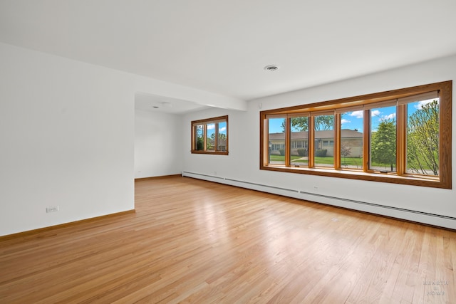 spare room featuring light hardwood / wood-style flooring and a baseboard heating unit