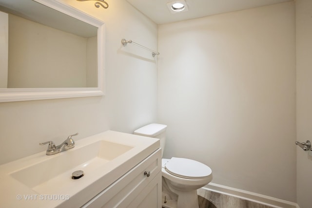 bathroom featuring hardwood / wood-style flooring, vanity, and toilet