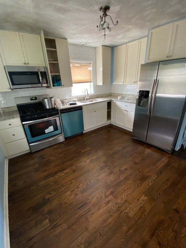 kitchen with dark wood-type flooring, white cabinetry, appliances with stainless steel finishes, sink, and tasteful backsplash