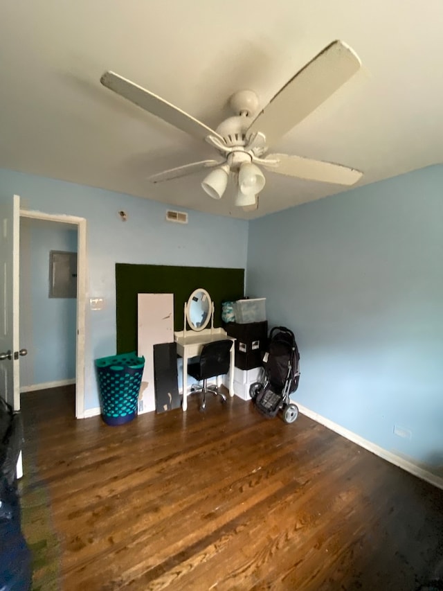 home office with dark hardwood / wood-style floors and ceiling fan