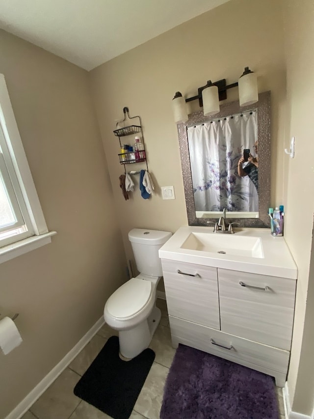 bathroom featuring tile flooring, vanity, and toilet