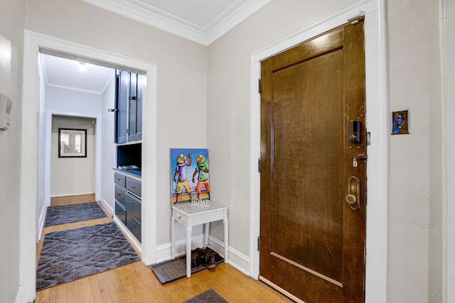 foyer entrance with crown molding and wood-type flooring