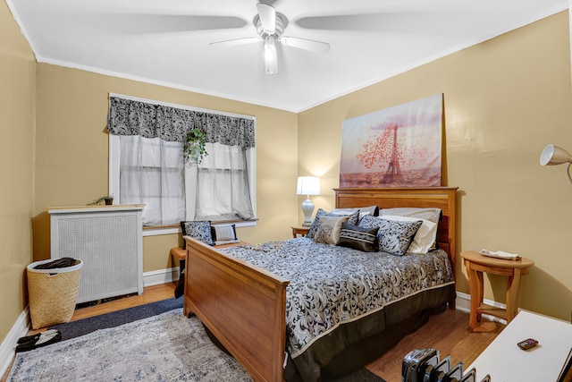 bedroom featuring ornamental molding, ceiling fan, hardwood / wood-style flooring, and radiator heating unit