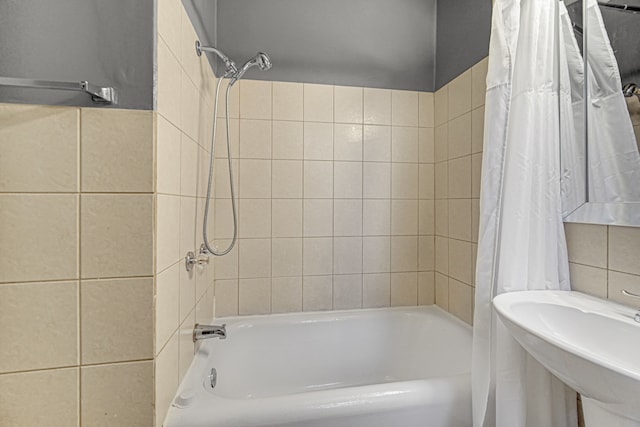 bathroom with tile walls, sink, and shower / bath combination with curtain