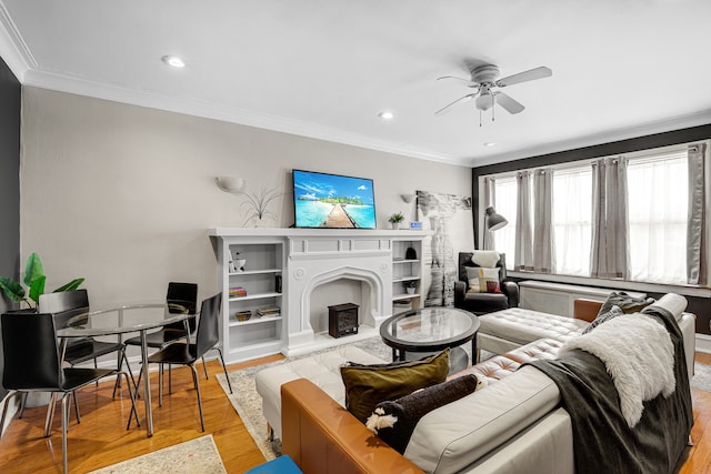 living room with crown molding, ceiling fan, and light wood-type flooring