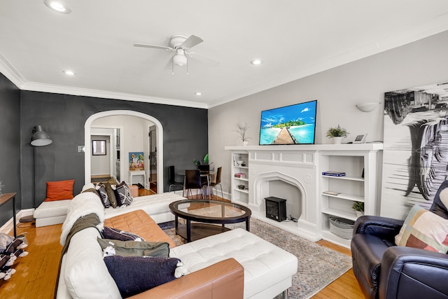 living room featuring ceiling fan, crown molding, and light wood-type flooring