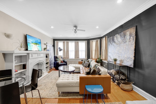 living room featuring ornamental molding, ceiling fan, and light wood-type flooring